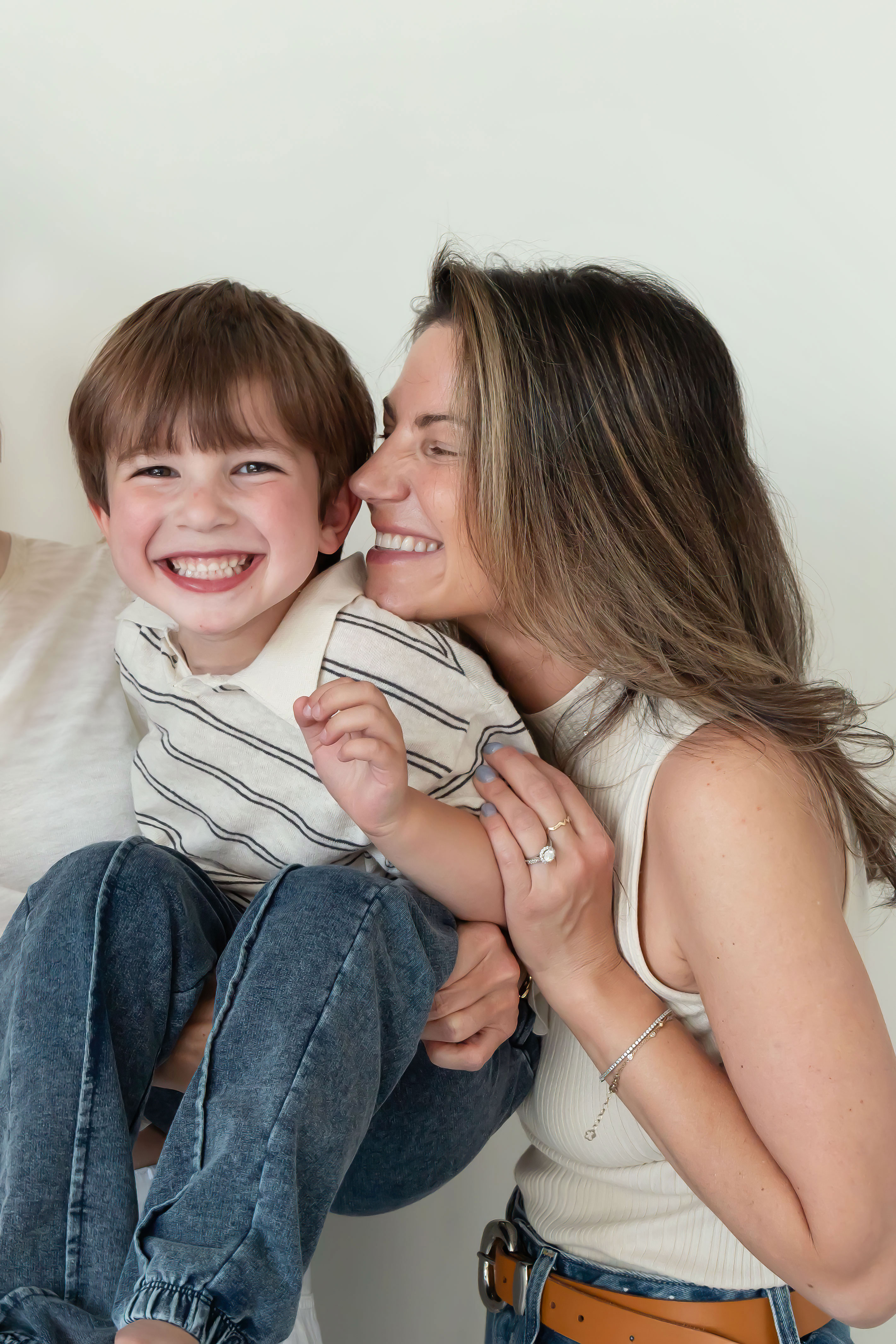 Mother laughing with her two young sons during an in-home lifestyle family photography session by a Cleveland family photographer.
