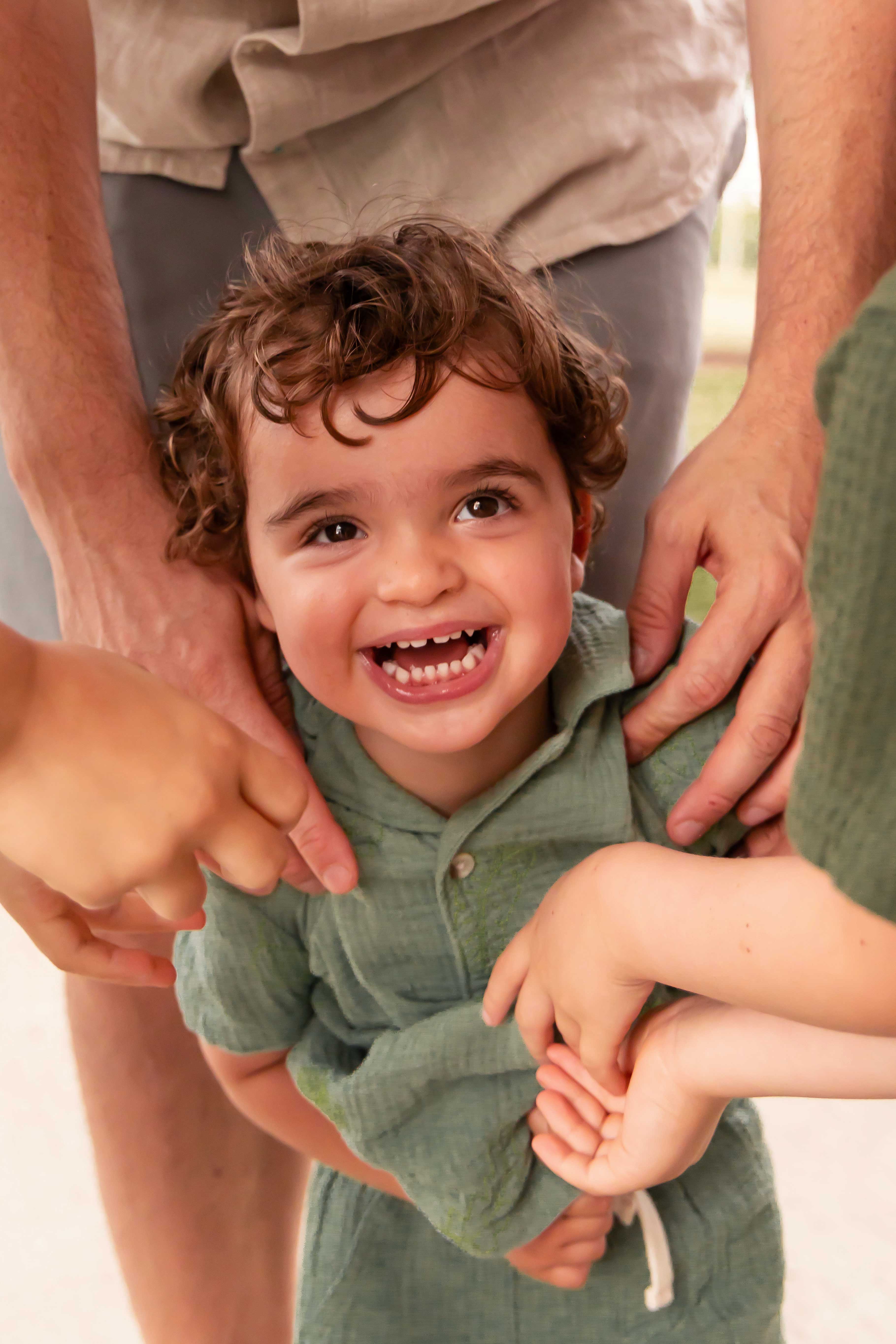 Young boy being tickled by his family in an outdoor sunset photography session in Cleveland, Ohio
