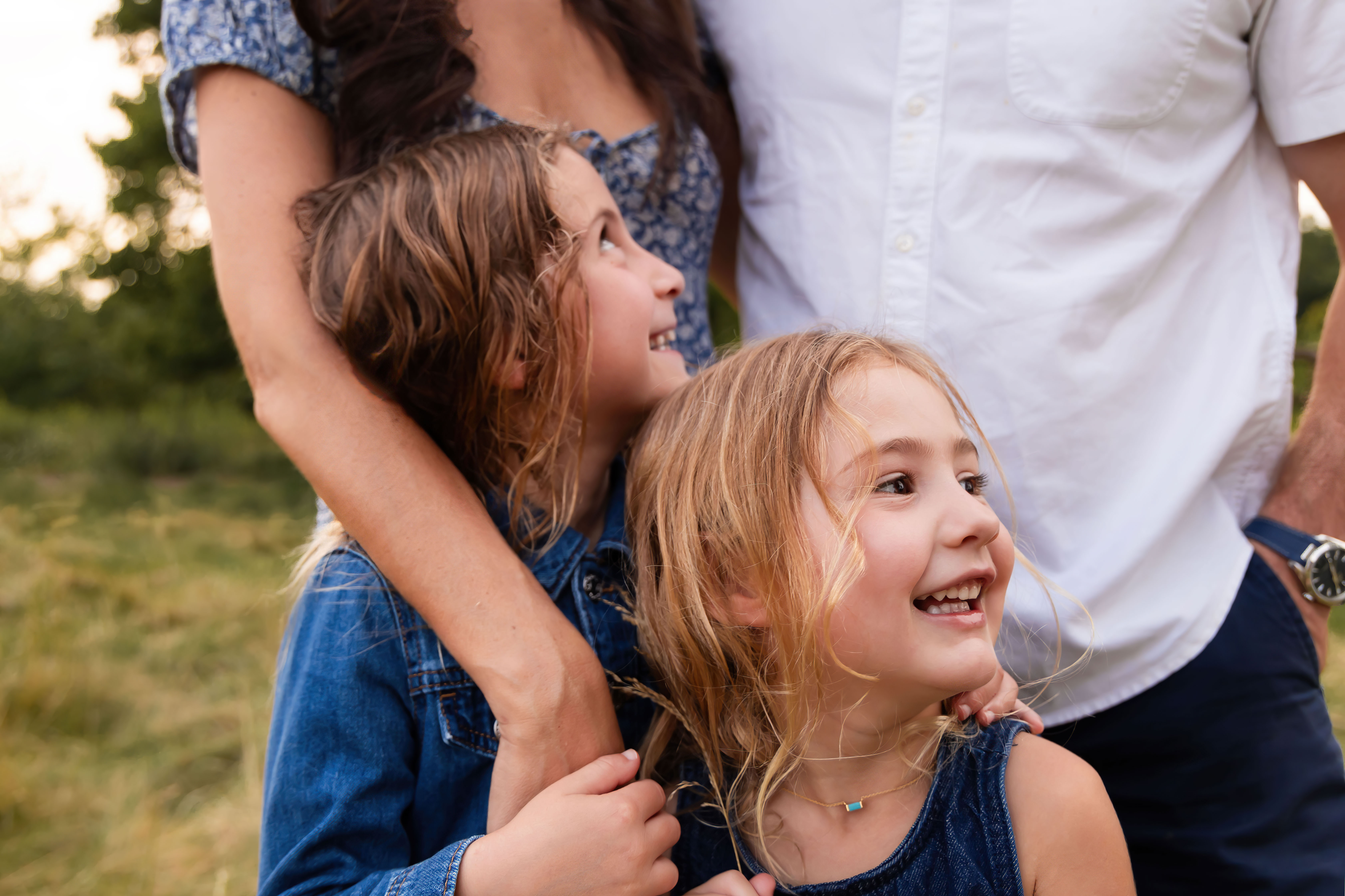 Two young sisters cuddling together during an extended family photography session