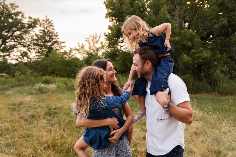 Family gathered together in a field during a golden hour Cleveland photography session