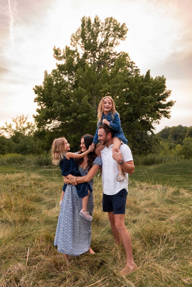 Family with daughter on dads shoulders during a beautiful Cleveland sunset photography session