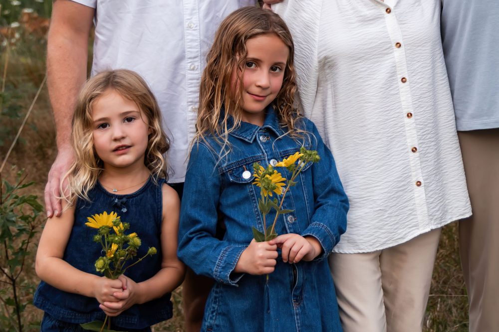 Young girls holding wildflowers during a Cleveland family photography session