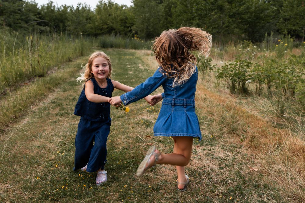 Two sisters laughing together during an outdoor Cleveland family photo session
