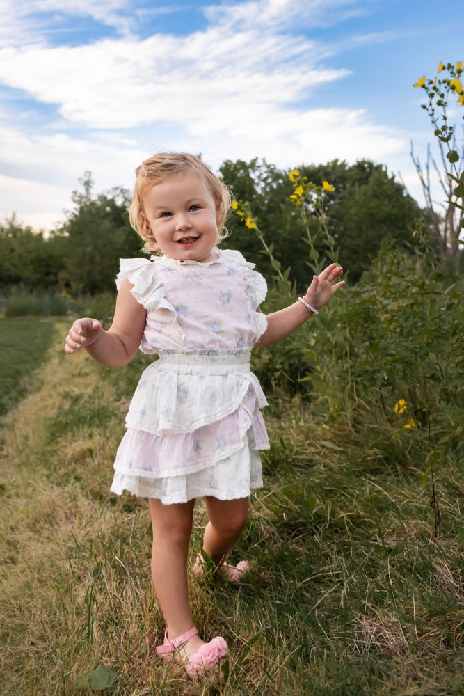 Little girl holding a wildflower during a natural outdoor family photography session in Cleveland Ohio