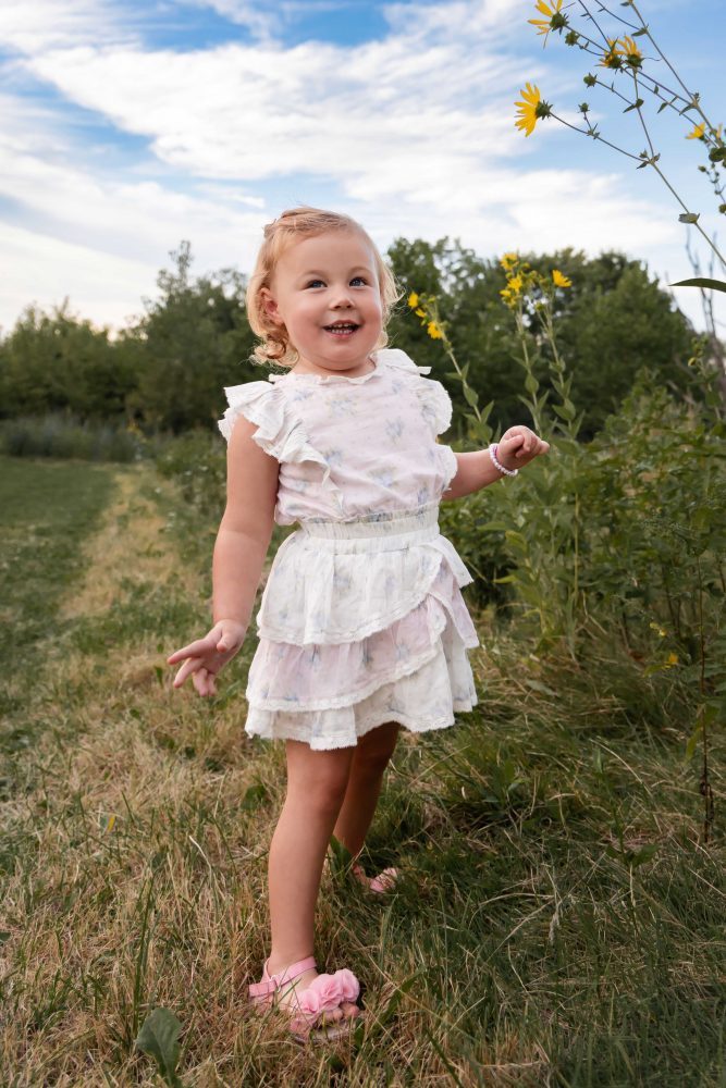 Little girl holding a wildflower during a natural outdoor family photography session in Cleveland Ohio