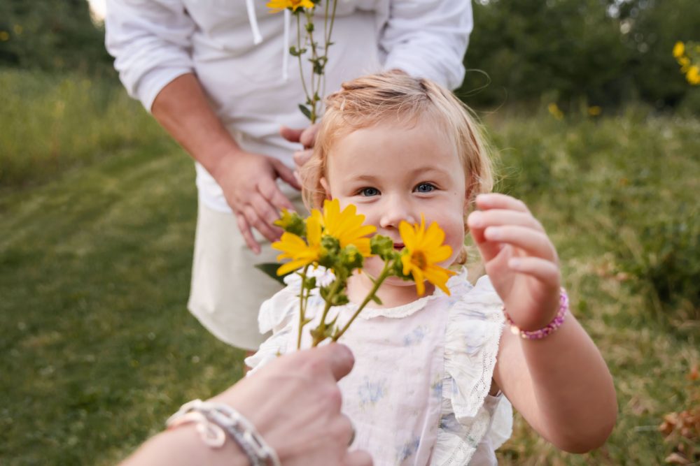 Cleveland family photographer captures a young daughter smiling among yellow wildflowers