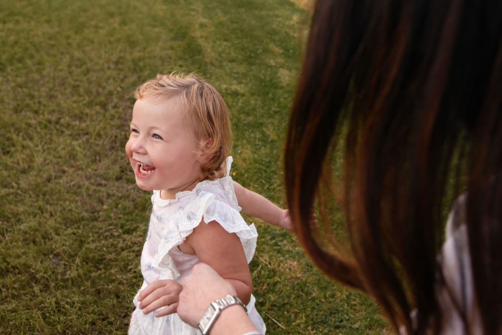Young girl running with mom during a Cleveland family photography session