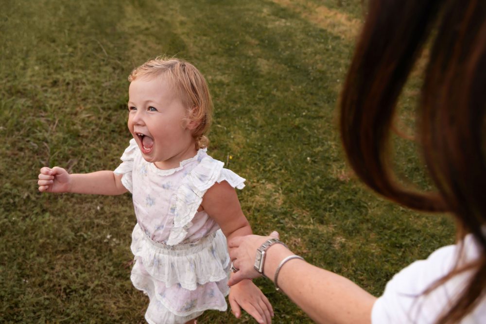 Young girl running with mom during a Cleveland family photography session