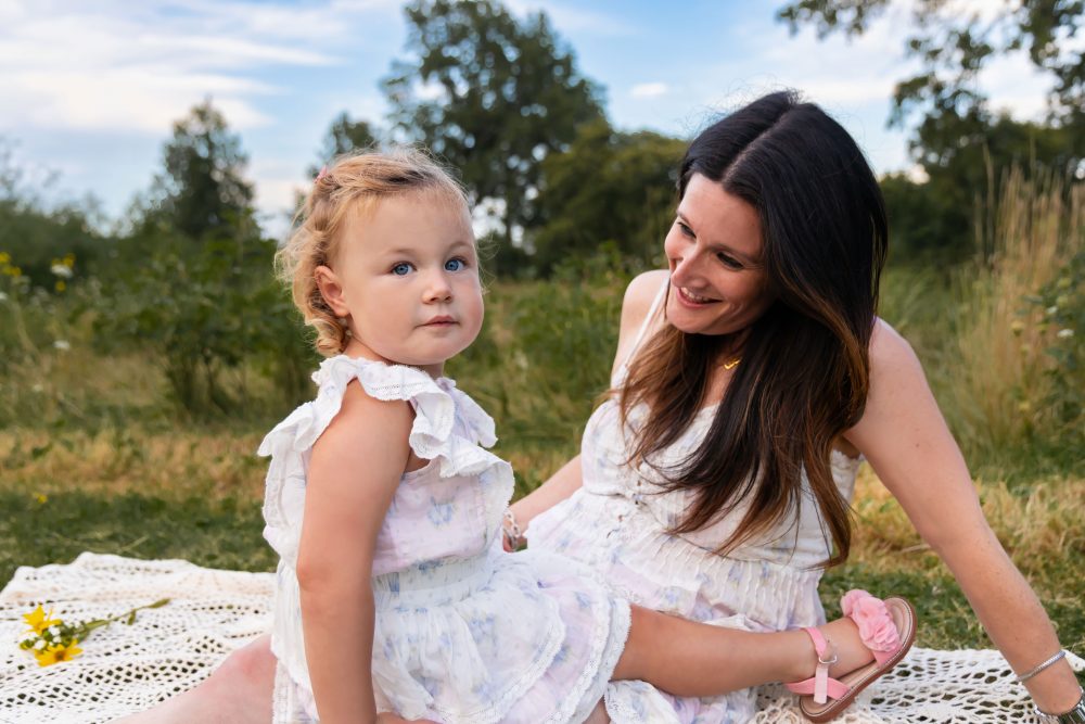 Mom sitting with her young daughter during a natural outdoor family photography session in Cleveland