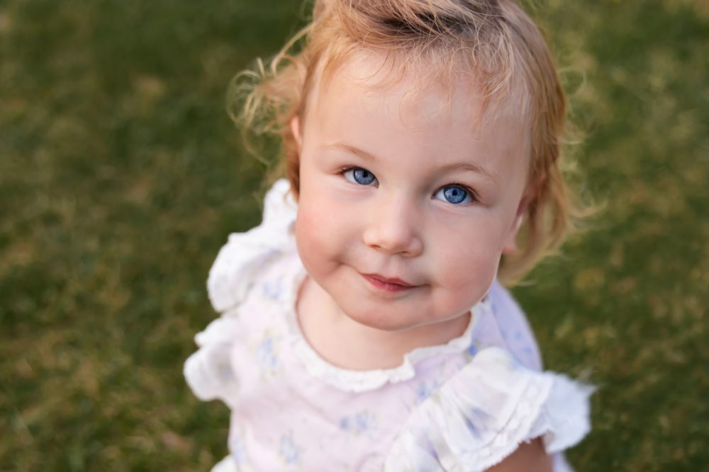 Cleveland family photographer captures a young daughter smiling among yellow wildflowers