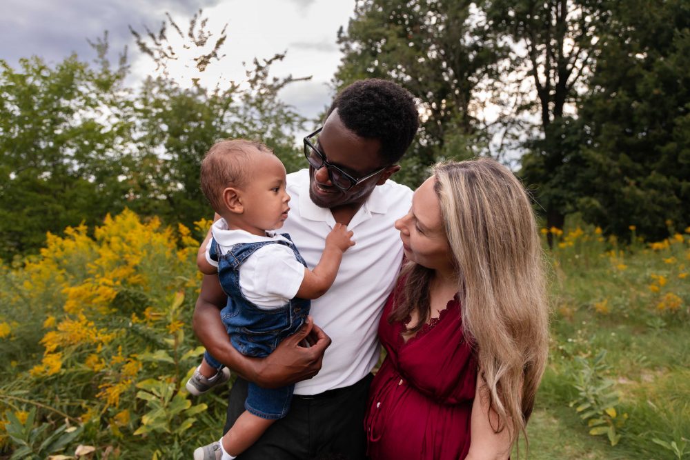 Dad holding his baby while standing with his wife and young son during a Cleveland family photography session.