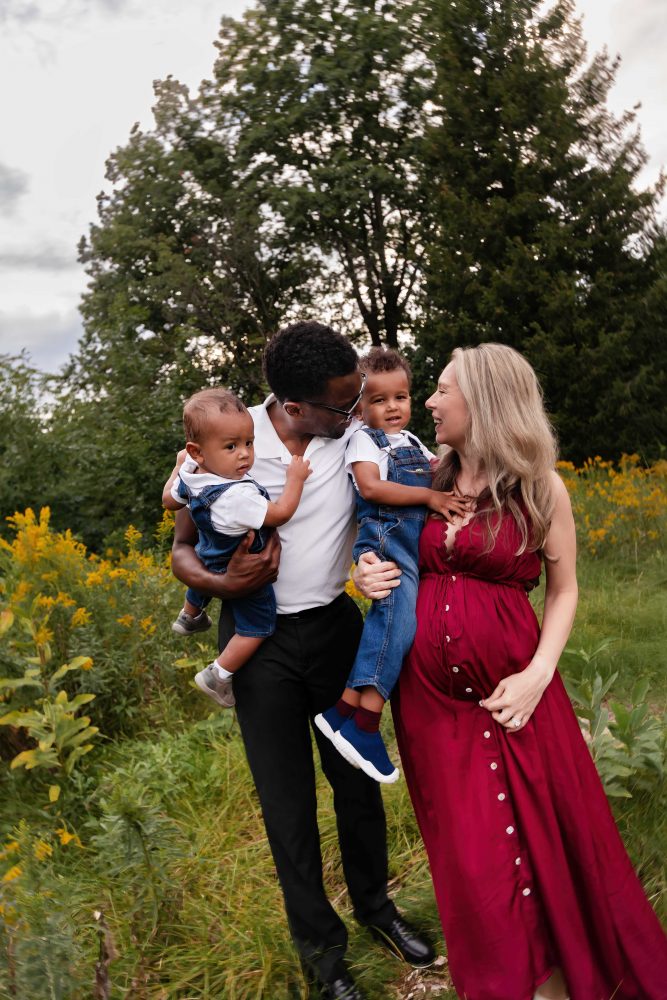 Cleveland family photographer capturing a relaxed family portrait surrounded by tall grasses and golden wildflowers.