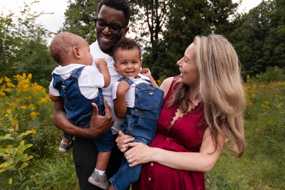 Cleveland maternity photography portrait of an expectant mother surrounded by wildflowers and tall grasses.