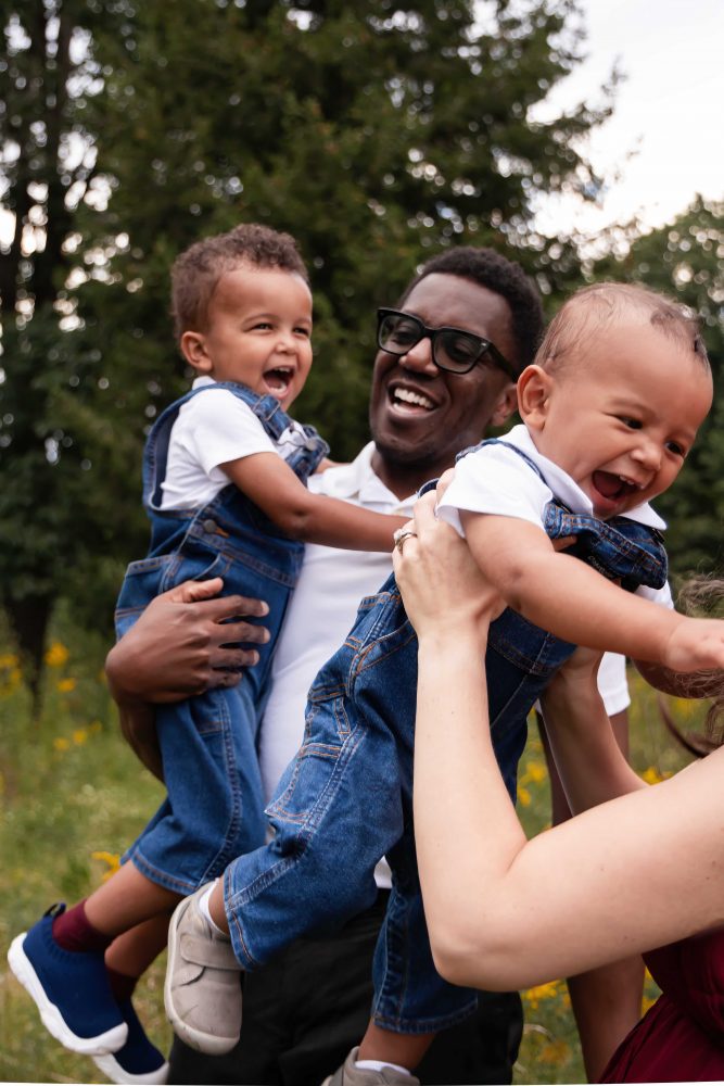 Parents laughing with their two young sons during a natural family photography session in Cleveland, Ohio.