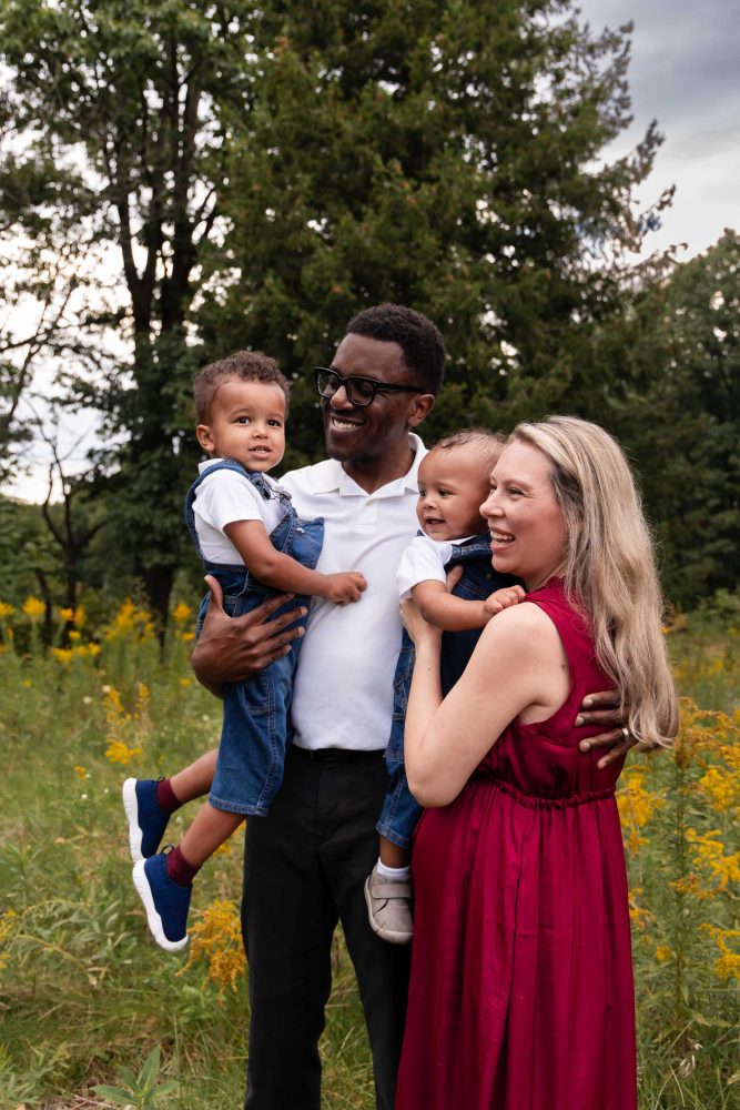 Cleveland family photographer capturing a candid moment between parents and their two children outdoors.