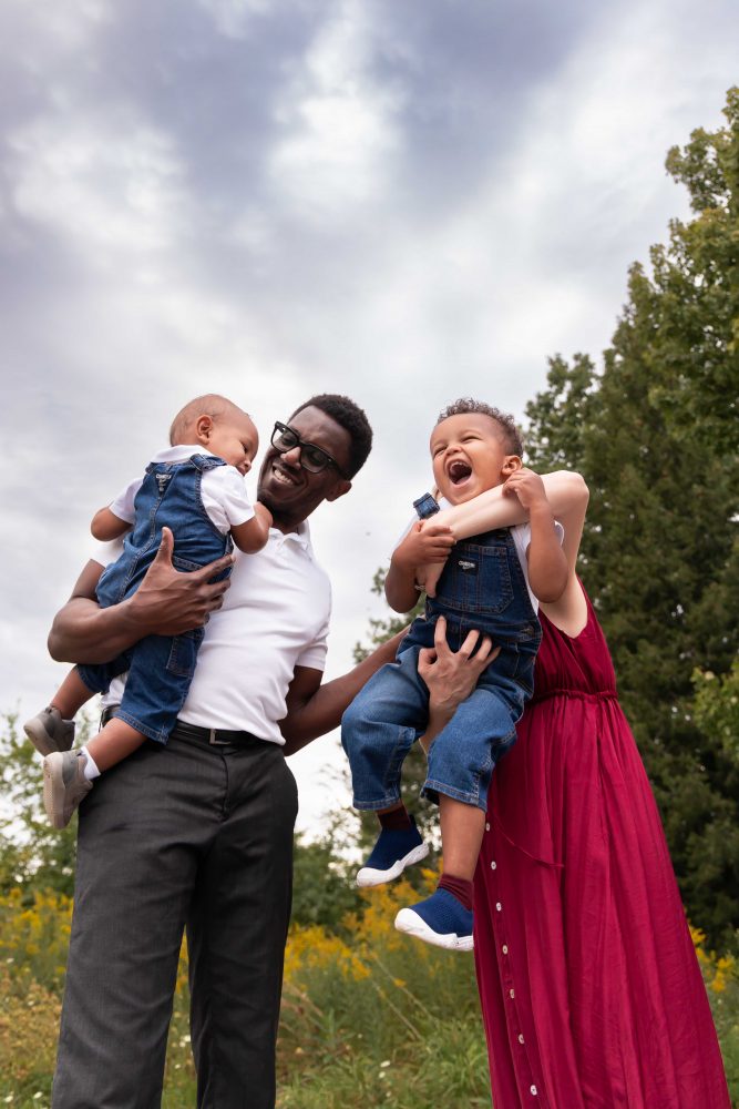 Outdoor family portrait of parents and their two boys among wildflowers by Allison Liffman Photography.