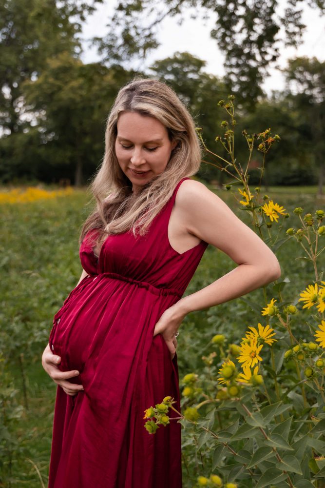 Natural maternity portrait of an expectant mother surrounded by yellow flowers and greenery in Cleveland.