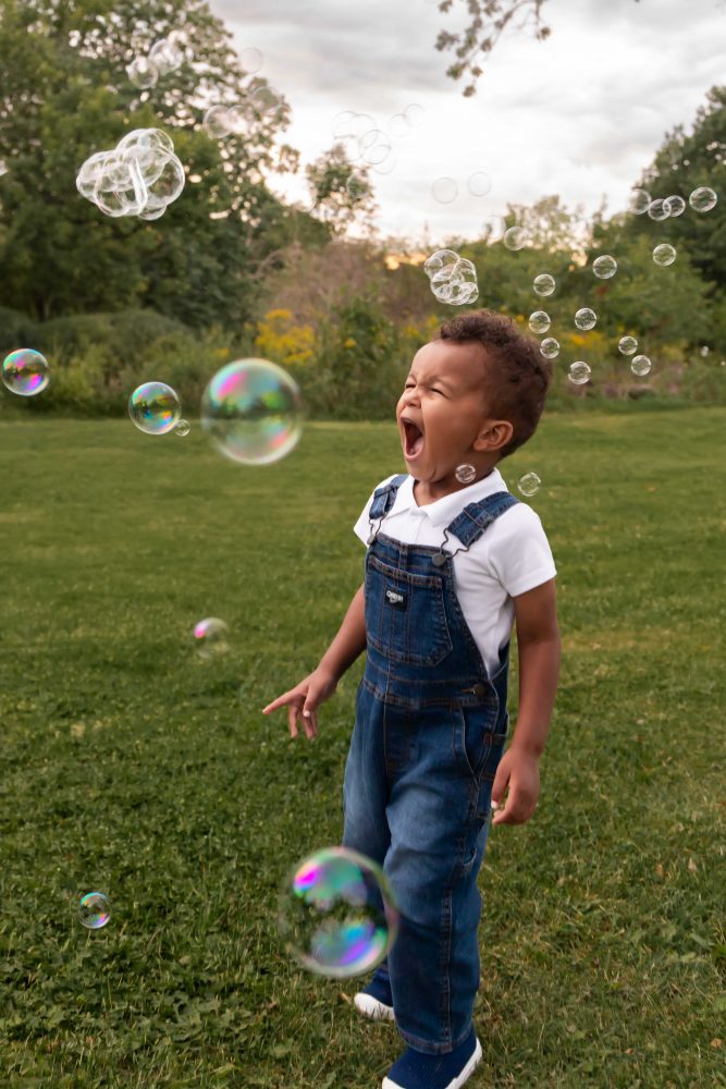 boy playing with bubbles during an outdoor family photoshoot in Cleveland, Ohio