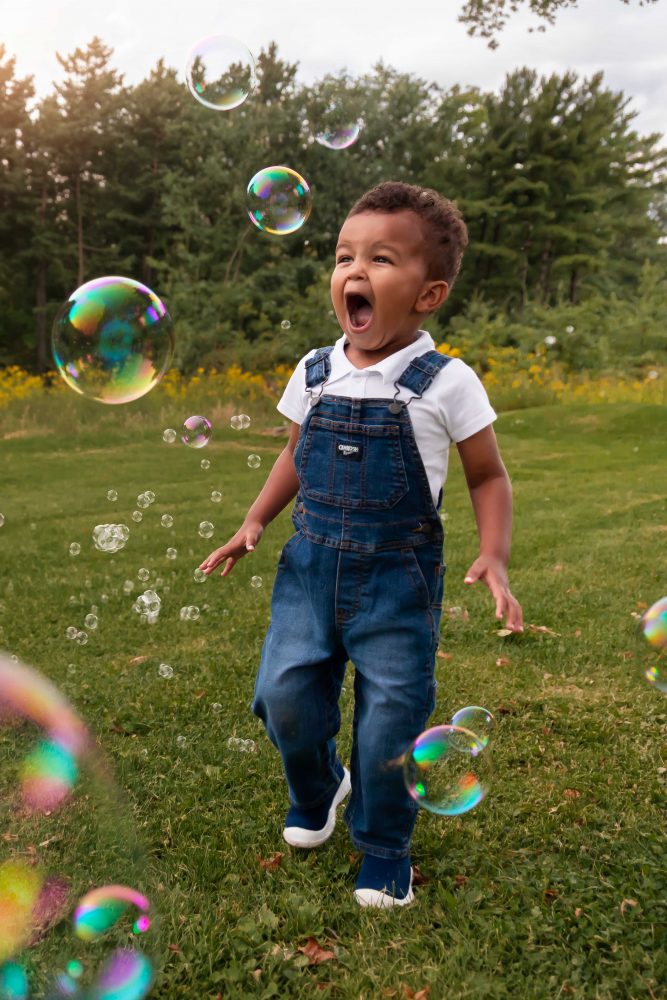 boy playing with bubbles during an outdoor family photoshoot in Cleveland, Ohio