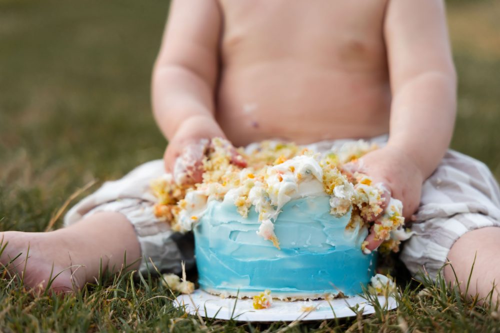 First birthday cake smash photography by Allison Liffman Photography in Cleveland, Ohio, featuring a happy baby and a colorful cake.