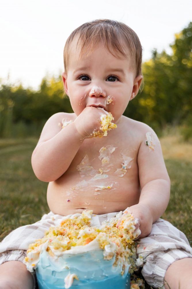 First birthday cake smash photography by Allison Liffman Photography in Cleveland, Ohio, featuring a happy baby and a colorful cake.