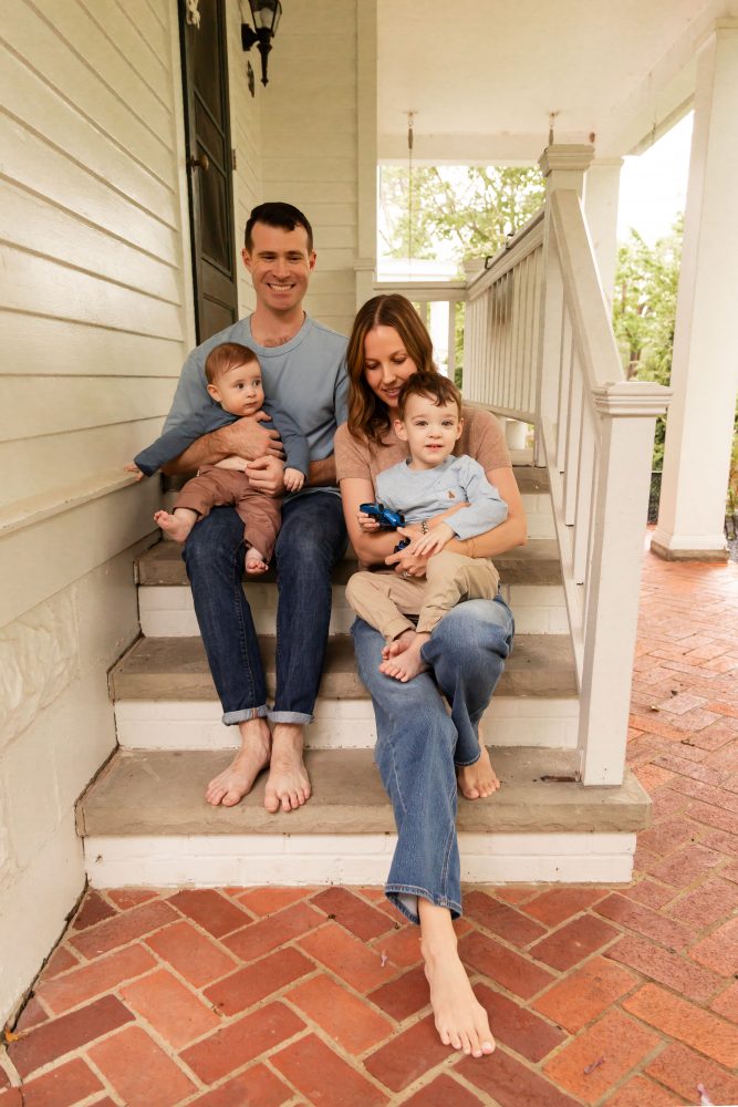Cleveland family photography session on a covered porch with parents and two young boys.