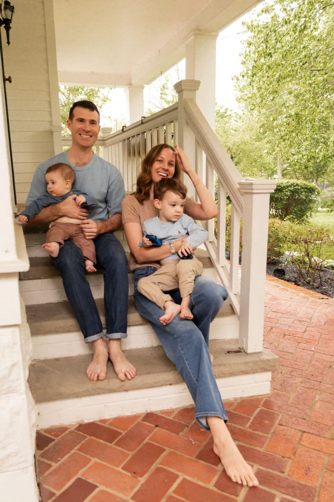 Cleveland family photography session on a covered porch with parents and two young boys.