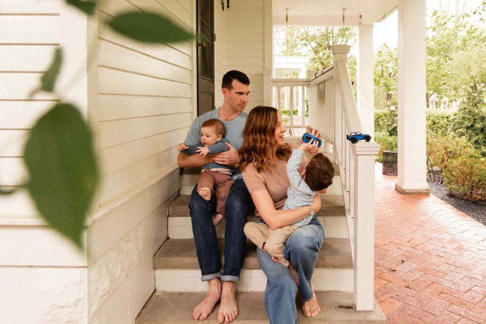 Parents playing with their two young sons during a playful at-home family photo session.