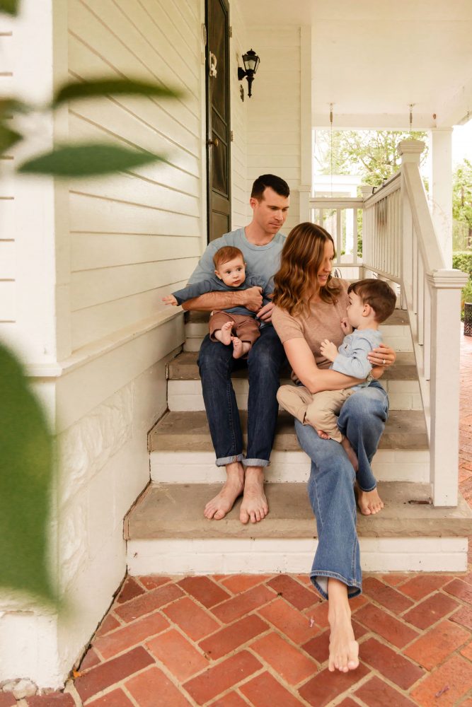 Parents playing with their two young sons during a playful at-home family photo session.