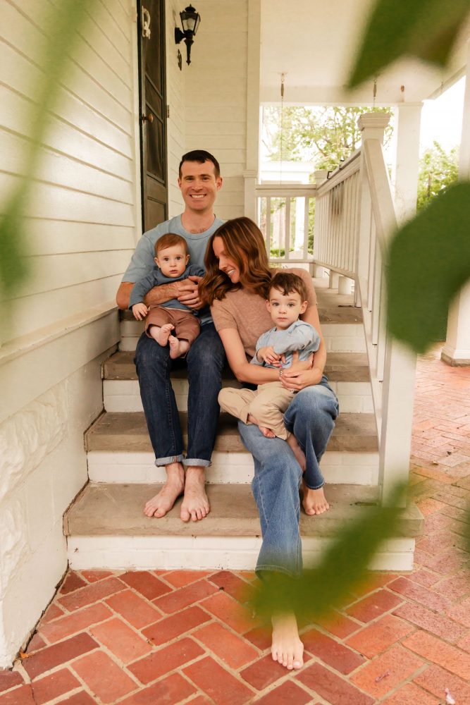Parents playing with their two young sons during a playful at-home family photo session.