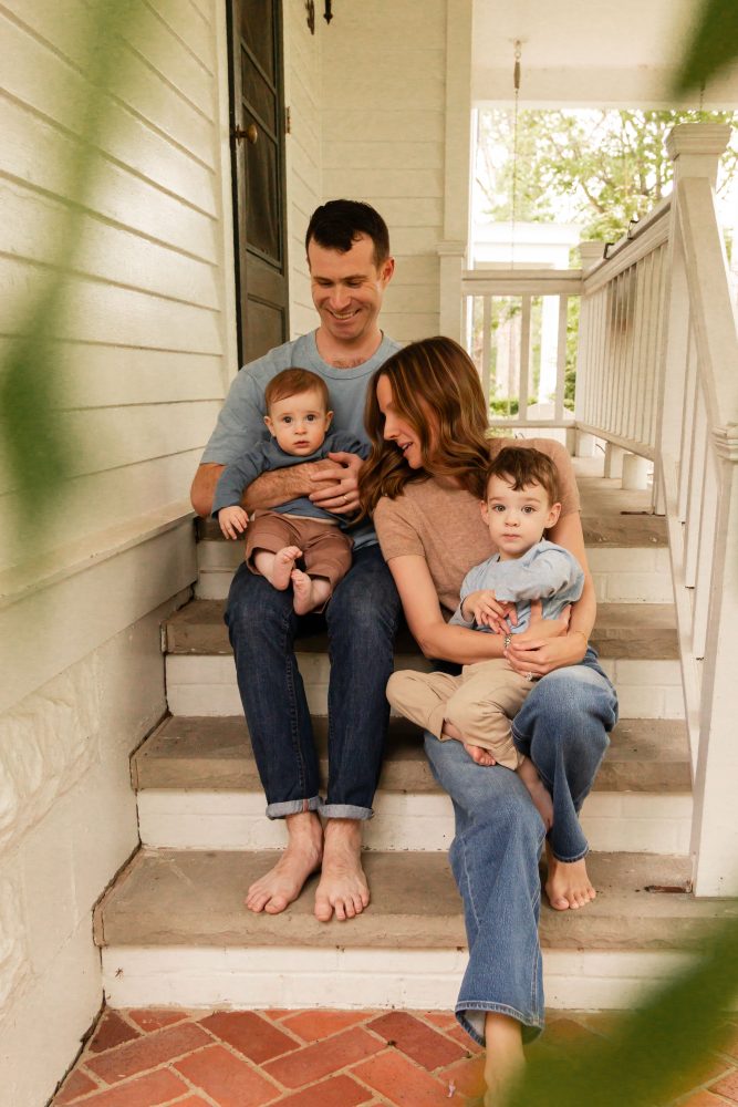 Parents playing with their two young sons during a playful at-home family photo session.
