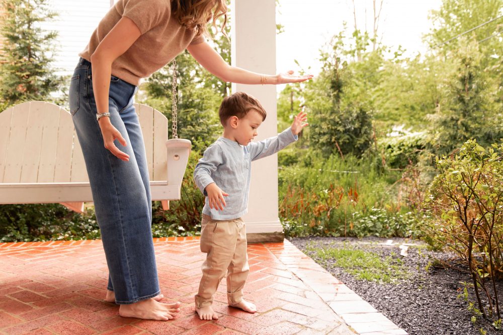 Warm and timeless mother-and-child photography with white porch railings framing the family.
