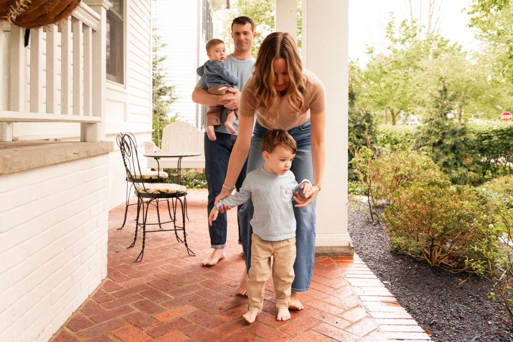 Warm and timeless mother-and-child photography with white porch railings framing the family.